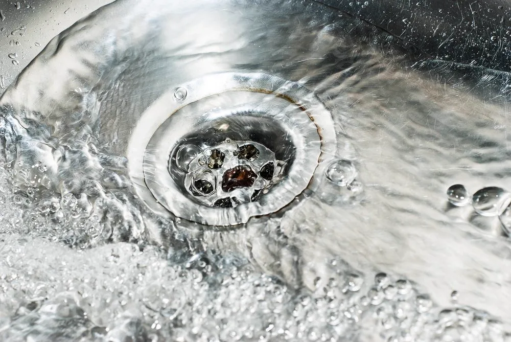 Water swirling away slowly down a partly blocked drain outlet