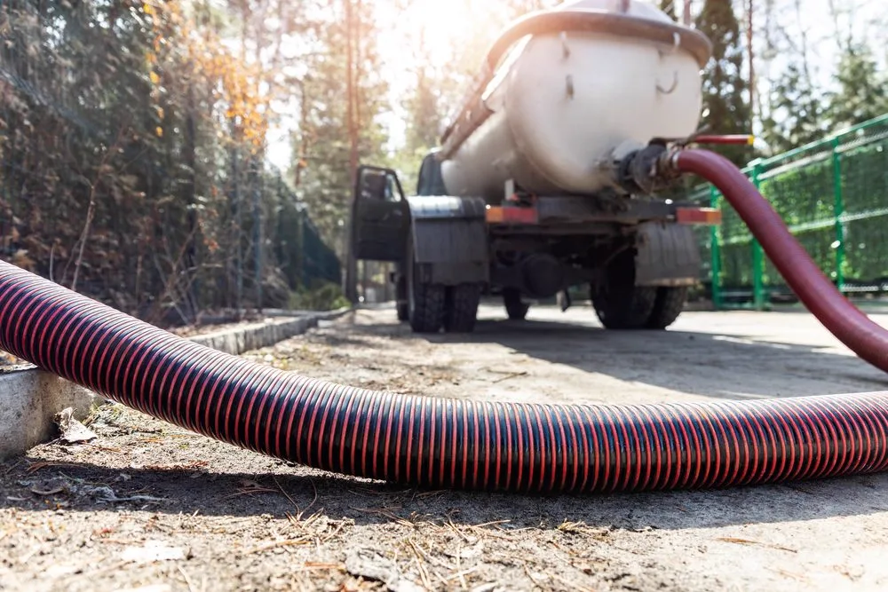 Vacuum truck and suction hose on site during a drain cleaning job