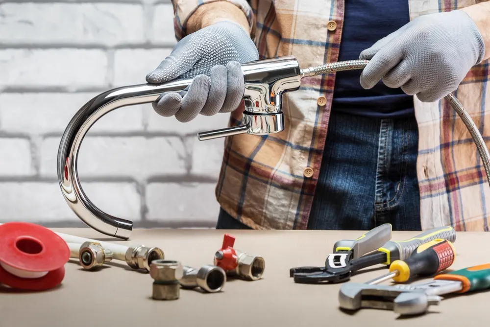Drainage fittings and hand tools laid out on a work bench before a job