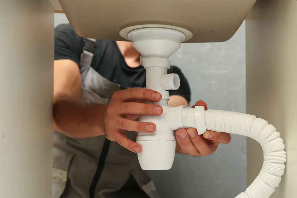 Replacing a waste trap and flexible drain hose under a kitchen sink