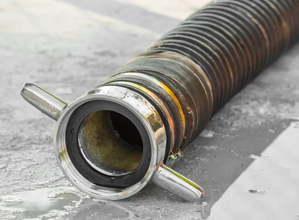Section of drain pipe cut open showing sludge build-up before drain cleaning