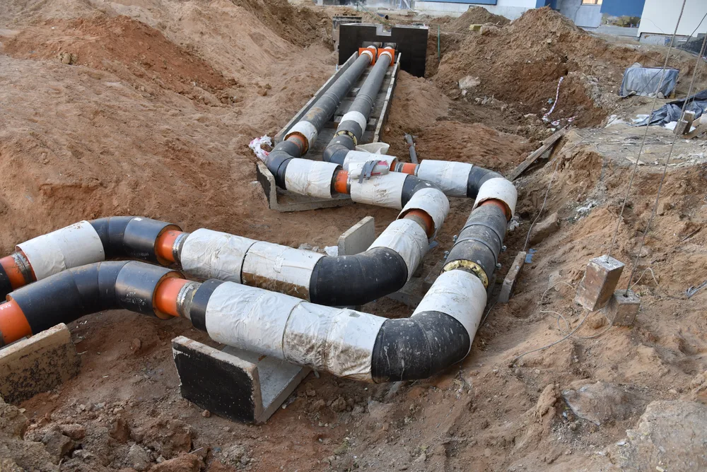 New drainage pipework assembled in an open excavation on a residential block