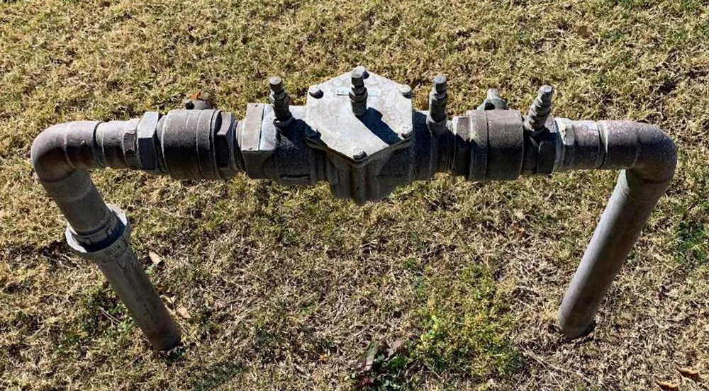 Poly drainage pipe joined and laid across grass during a drainage upgrade
