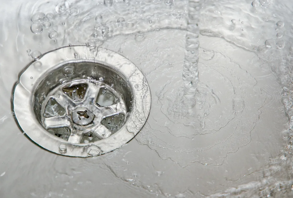 Water sitting in a stainless sink waste from a blocked drain in a Brisbane home