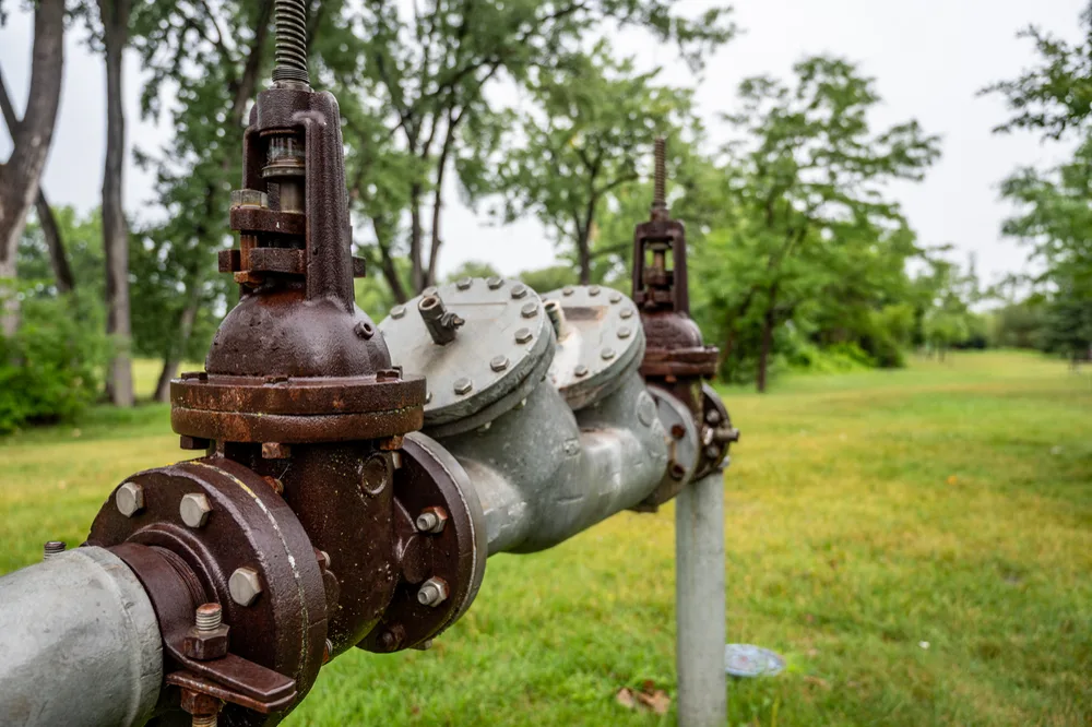 Heavy cast valve set on a stormwater main beside a suburban park